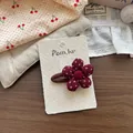 Dettaglio di un fermaglio per capelli in tessuto a fiori rossi con bottone centrale - Fermaglio per Capelli Fiore a Pois