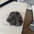 Nahaufnahme eines dunkelgrauen Plüsch-Haargummis für einen Vintage-Herbst-Look - Grau