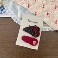 Detail of red floral and polka dot fabric hair clips set on beige display card - Red Polka Dot Style