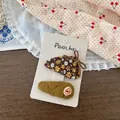 Détail de barrettes à fleurs et tissu matelassé avec petite rose sur carte support - Style Floral Jaune
