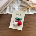 Dettaglio del fermaglio per capelli a ciliegia e gatto in tessuto su sfondo rustico - Fermaglio per capelli / Ciliegia Rossa