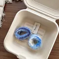 Detailansicht von zwei flauschigen Strick-Haargummis in blau-violetten Batikmustern - Plüsch-Strick-Haargummi / Dunkelblau + Hellblau