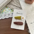 Detailed view of vintage fabric hair clips with daisy buttons on a rustic display card - Flower And Plaid Teardrop Style