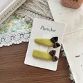 Dettaglio di due fermagli per capelli in tessuto fatti a mano con fiocchi marroni - Stile Goccia E Fiocco Quadrato