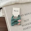 Detailed view of two dark green linen bow hair ties with cute mushroom embroidery - Green Ink Bow Scrunchie