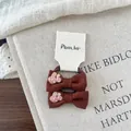 Detail view of brown fabric hair bows with cherry embroidery and high elastic bands - Brown Bow Hair Tie