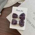 Dettaglio di due fermagli per capelli viola a fiori con pizzo su carta espositiva - Viola scuro