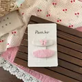 Dettaglio dei fermagli per capelli in tessuto con fiocchi rosa su carta bianca - Fermaglio Ovale con Fiocco