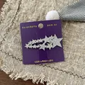 Macro shot of sparkling silver sequin stars on a purple display card with beige fabric - Silver Star