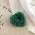 Close-up of fluffy dark green lamb wool hair claw with soft plush texture and round shape - Green Hair Claw