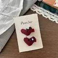 Dettaglio di fermagli per capelli a cuore rosso a pois con fiocchi e perle su carta - Fermaglio per Capelli con Perla a Cuore Rosso Scuro