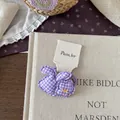 Detail von lila karierten Stoff-Haargummis mit Blumen- und Hasenmotiven auf Karte - Gingham Hasen-Blumen-Haargummi