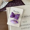 Detailed macro view of purple floral fabric bow and lavender embroidery hair clips on card - Bright Purple Flower Bud Clip