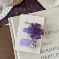 Detail von koreanischem Haarspangen-Set mit lila Blumenstoff und gestreifter Schleife - Florale Blume und Quadratischer Clip