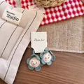 Dettaglio di accessori per capelli a fiori all'uncinetto con viso sorridente ricamato - Elastico per capelli / Blu