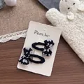 Détail de barrettes à cheveux faites main en tissu à motif cœur sur carte de marque - Noir