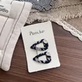 Close-up of fabric-wrapped BB hair clips with vintage buttons on a white textured card - Black Heart (Item: NK1634)