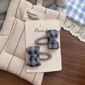 Détail de barrettes à nœuds en tissu à carreaux bleu et gris sur carte blanche - Barrette à Nœud Écossais