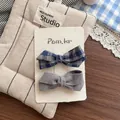 Détail de barrettes à nœuds en tissu à carreaux bleus et gris sur carte de support - Paire de Pinces à Cheveux Nœud Noué