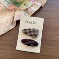 Dettaglio di fermaglio in peluche marrone e fiocco in velluto a coste su carta bianca - Bottone Viola Scuro