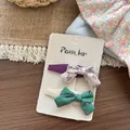 Vista dettagliata dei fermagli a fiocco in cotone floreale viola e verde su card - Fermaglio con Stampa Fiocco
