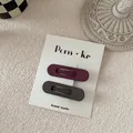 Macro detail of matte teardrop BB hair clips set in dark purple and deep gray tones - Dark Red And Gray Oval Style