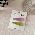 Detailed macro view of pink and olive green matte metal BB hair clips on brand card - Pink And Green Water Drop Style