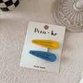 Detail of matte waterdrop hair clips in yellow and blue on white card packaging - Yellow And Blue Water Drop Style