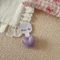 Close-up of a sweet purple mesh heart hair tie displayed on a white paper card - Purple Heart