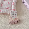Detalle de gomas para el pelo de gato rosa sobre tarjeta blanca y fondo de cuadros - Estilo Coletero / Goma de Pelo Gato Rosa
