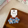 Detailed macro view of blue fabric floral hair ties with elastic bands on a display card - Blue