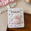 Dettaglio delle mollette rosa in tessuto con stampa coniglietto e fiocco su carta - Fermagli per Capelli Coniglio Rosa