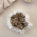 Dettaglio dell'elastico per capelli floreale con pizzo bianco e tessuto marrone - Marrone Floreale