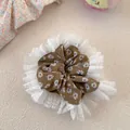 Dettaglio dell'elastico per capelli floreale con pizzo bianco e tessuto marrone - Marrone Floreale