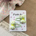 Detalle de dos lindas pinzas para el cabello con lazo floral para niñas en cartón - Pinza de Lazo Floral Verde