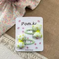 Detalle de dos lindas pinzas para el cabello con lazo floral para niñas en cartón - Pinza de Lazo Floral Verde