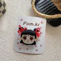Gros plan d'une barrette à cheveux brodée avec personnage de dessin animé sur carte - Pince à cheveux personnage