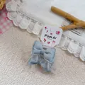 Detail of blue denim bow hair tie with white lace mesh on a floral card display - Blue