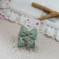 Dettaglio di elastici per capelli con fiocco a righe verdi e fodera in pizzo bianco - Verde