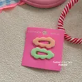 Detail of candy color wave hair clips set in light orange and green on decorative card - Skin and Light Green