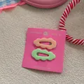Detail of candy color wave hair clips set in light orange and green on decorative card - Skin and Light Green