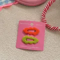 Detail of candy-colored wavy hair clips in orange and lime green on pink card - Orange-Red and Matcha Green
