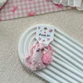Dettaglio di elastico rosa a forma di gatto con ricamo floreale e morbido pompon - Stile Pompon Gatto