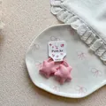 Close-up of pink plaid star hair ties on a ceramic plate with white lace decor - Star Polka Dot Hair Ties