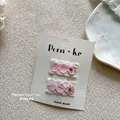 Dettaglio di fermagli per capelli rosa a scacchi con pizzo bianco e piccoli fiori - Fermagli per Capelli Tondi Plaid Pizzo