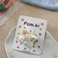 Détail de la pince à cheveux en tissu avec lapin mignon et rose sur une carte fleurie - Clip de Coussin Lapin Fleur Verte