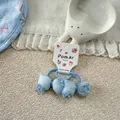 Detail of light blue bow hair tie with floral patterns and pearl on lace fabric - Blue