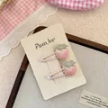 Detail of handmade embroidered strawberry hair clips with pearl beads on pink background - Pink Strawberry Style