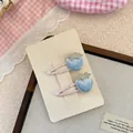 Dettaglio di mollette per capelli a fragola blu con ricami fini, perle e nastri rosa - Stile Fragola Blu