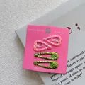 Détail de quatre barrettes pailletées roses et vertes pour filles sur support rose - Style 3 : Cœur Rose Vif et Goutte d'eau Verte